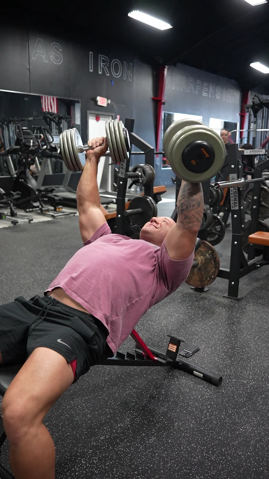 Zach Vazquez performing an incline dumbbell chest press at Strikeline